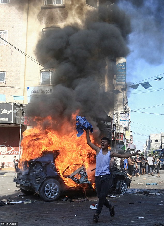 Last month, a senior Hamas official described the decision by Britain and other credulous Western nations to recognise a Palestinian state as 'one of the fruits of October 7'. Pictured: A Palestinian boy next to a burning Israeli vehicle Palestinian gunmen brought to Gaza after infiltrating Israel on October 7, 2023