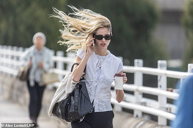 A woman's hair is blown in the wind as she crosses Waterloo Bridge in London this morning