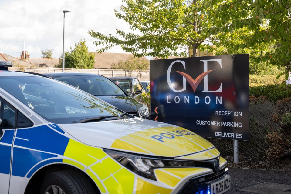 Police car parked outside GE London, a car dealership in administration.