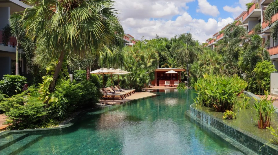 Resort pool with lounge chairs and a swim-up bar.
