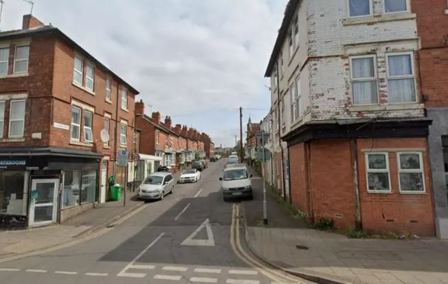 A street lined with buildings and parked cars.