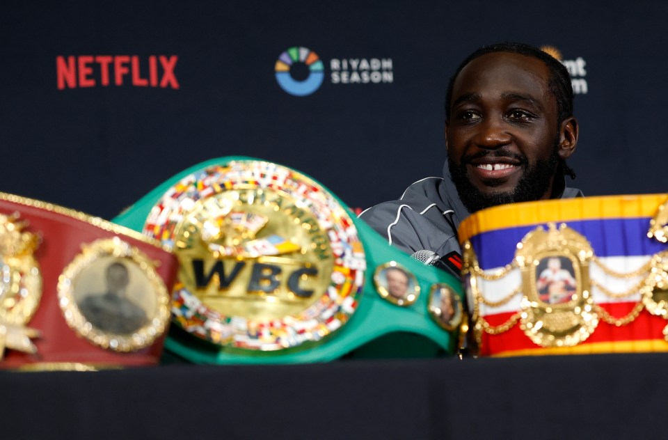 Terence Crawford at a press conference with boxing championship belts.