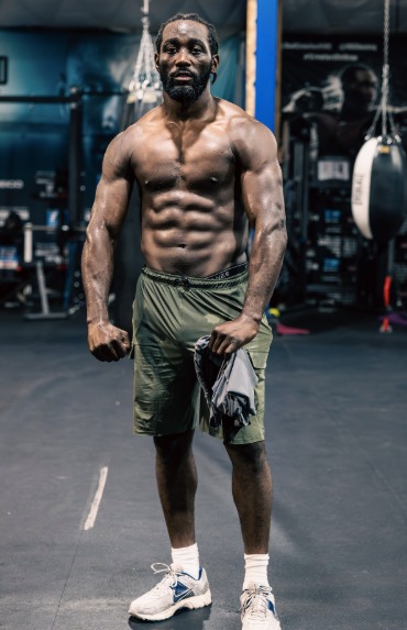Muscular man in gym holding towel.