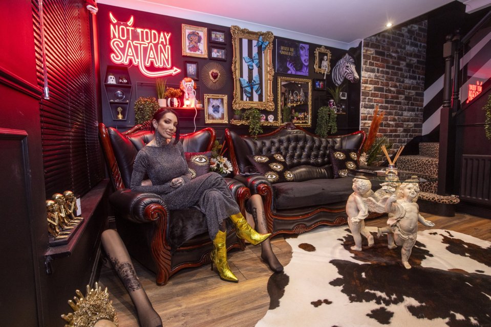 Ashleigh Anderson in her 'Goth House' living room with red neon sign and eclectic decor.