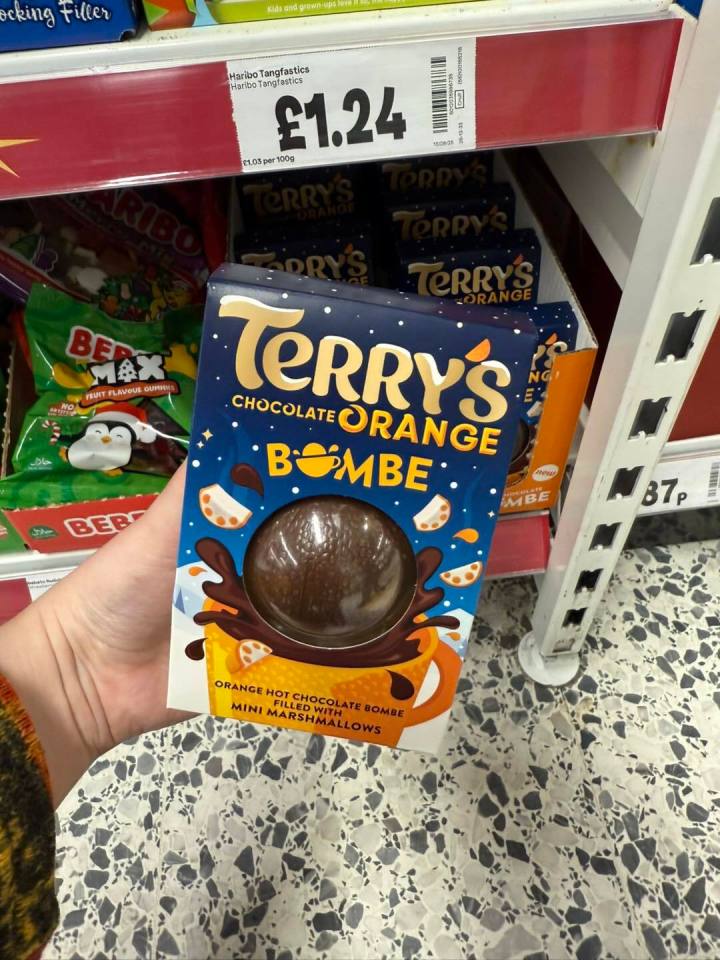A person holding a box of Terry's Chocolate Orange Bombe hot chocolate.