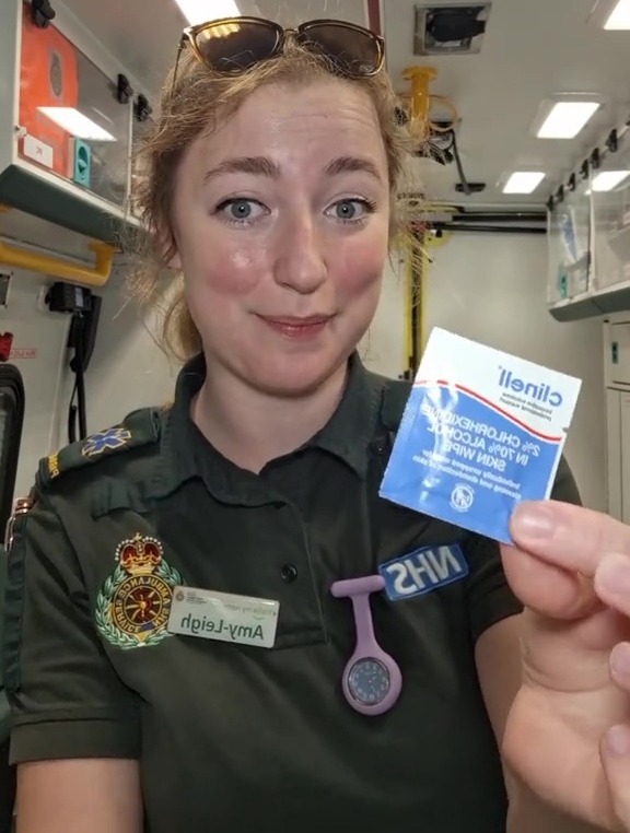 Paramedic holding up a chlorhexidine wipe.