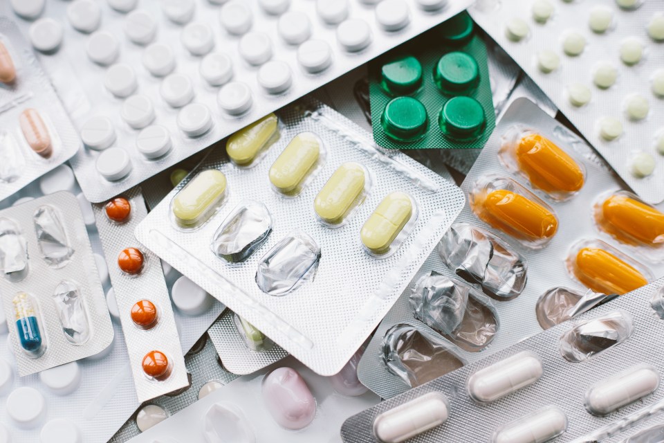 Close up of various pharmaceutical pills in blister packs, some partially used.