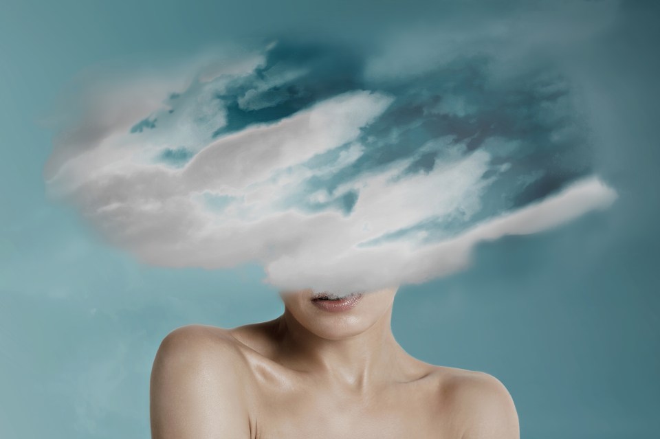 Woman head hidden by soft cloud on blue background, mental health, brain fog; Shutterstock ID 2177789901; purchase_order: -; job: -; client: -; other: -