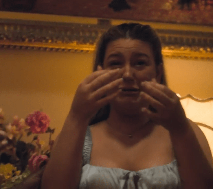 Woman crying, covering her face with her hands.