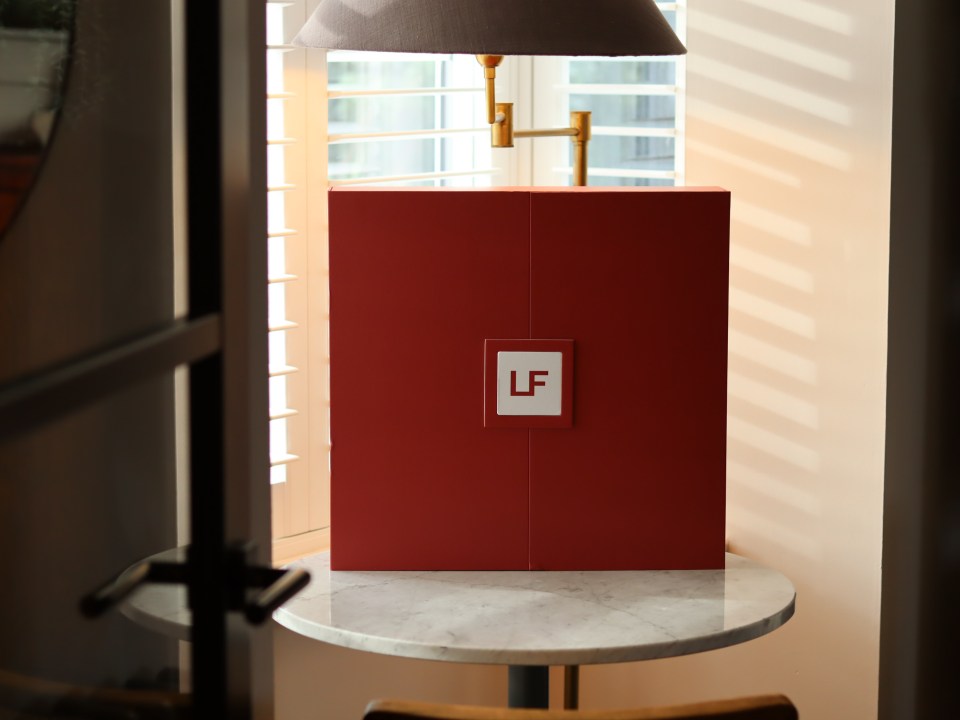 Red box with "LF" logo on a marble table.
