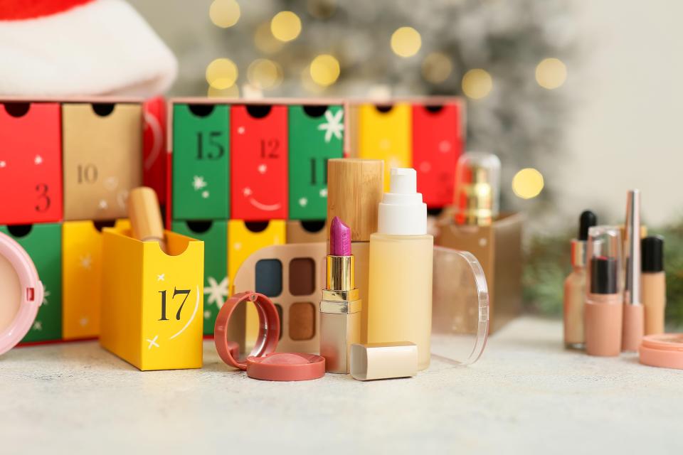 Makeup products in front of a Christmas advent calendar.