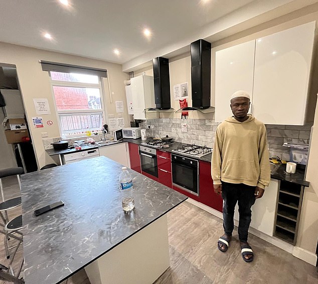 Mohamed Kamara stands in kitchen of his Home Office supplied terraced home in Nuneaton - one of thousands of asylum seekers being housed in private accommodation rather than hotel