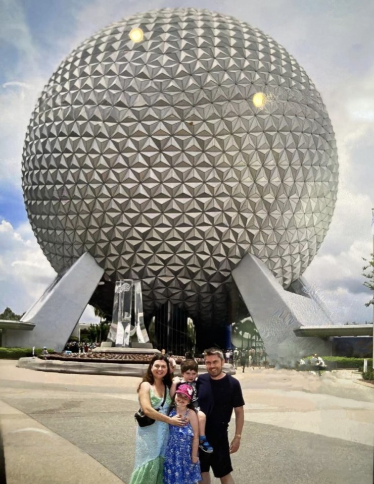 Family posing in front of Spaceship Earth at Epcot.