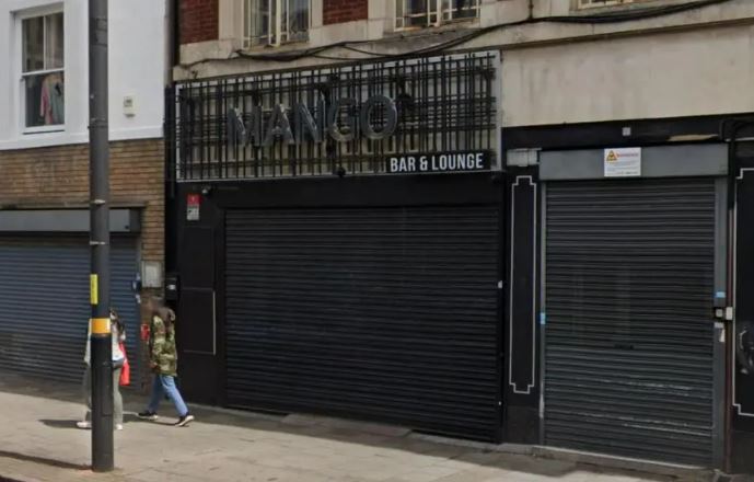 The storefront of a closed "Mango Bar & Lounge" with metal shutters down.