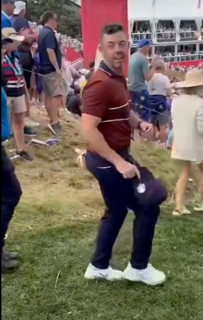 Rory McIlroy dancing and holding a hat.