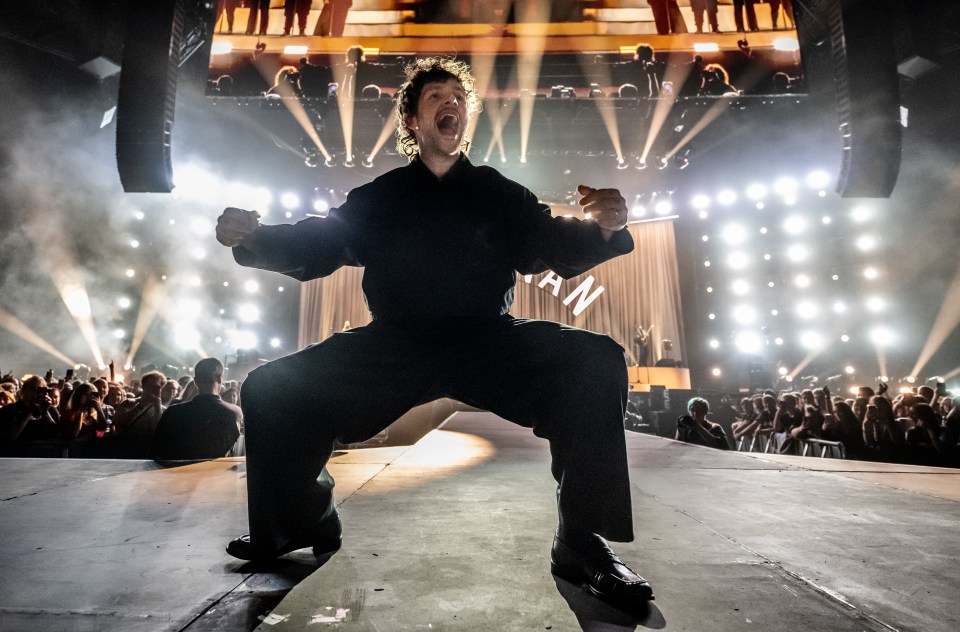 Tom Grennan performing on stage.