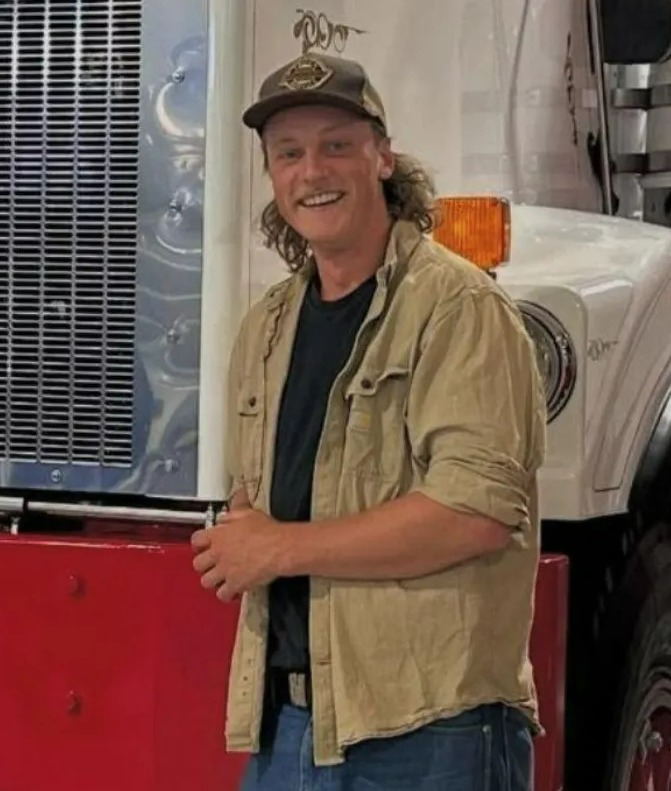 Man smiling next to a truck.
