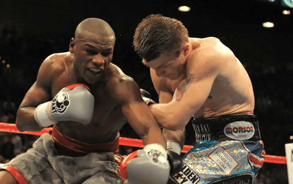 Two boxers fighting in a boxing ring.