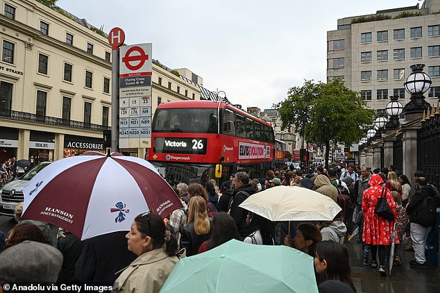 Citizens are seen waiting for a bus under the rain as the tube workers go on strike