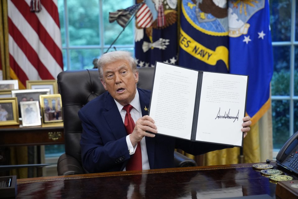 President Donald Trump holding up an executive order regarding TikTok in the Oval Office.