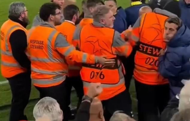 The Atletico Madrid member of staff (right) was caught on camera 'spitting' towards Liverpool fans