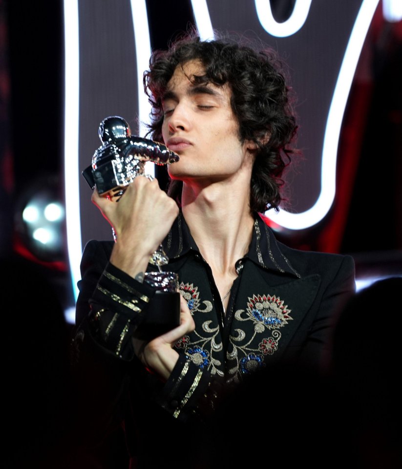 Sombr kissing a Moon Person award at the 2025 MTV VMAs.