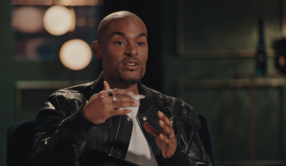 Paul C Brunson, wearing a black leather jacket, speaking and gesturing with his hands.