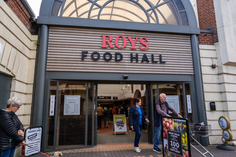 The entrance to Roy's Food Hall, with people entering and leaving the store.