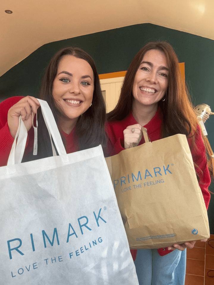 Two women holding Primark shopping bags.