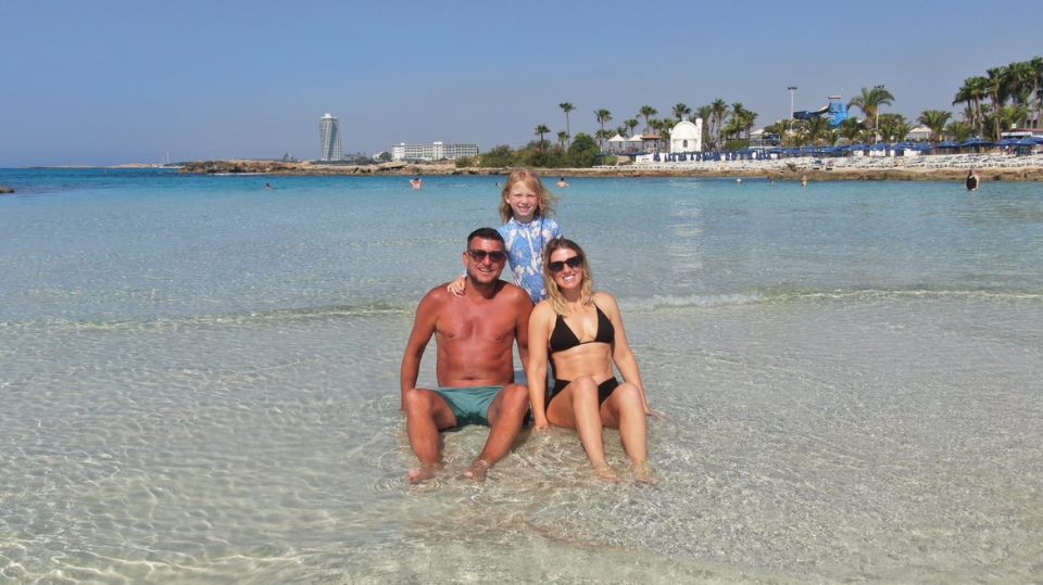 Family on a beach in shallow water.