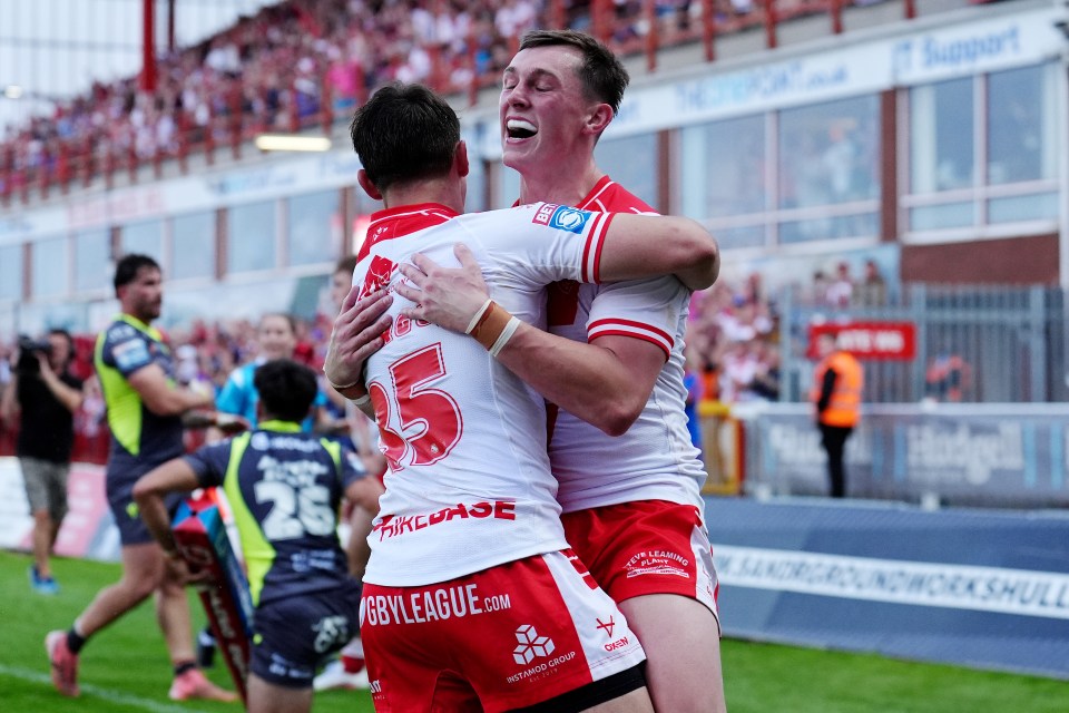 Two rugby players hugging after scoring a try.