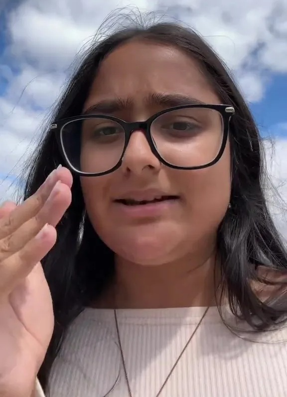 Woman with glasses and dark hair making a hand gesture with text "CENTRE AND HAND" overlaid.