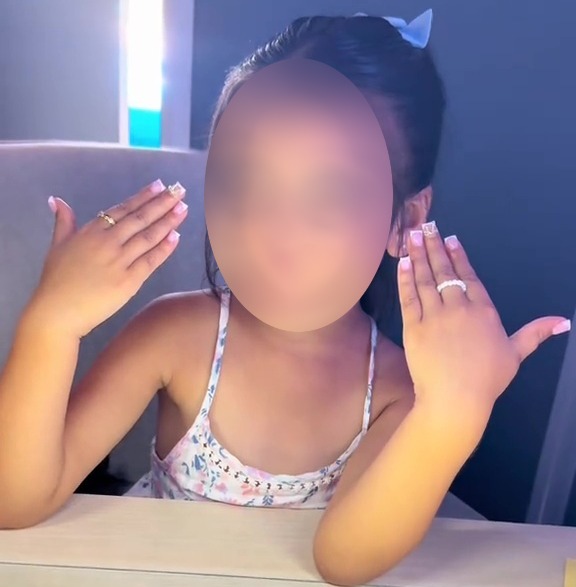 Girl showing off her manicured nails and rings.
