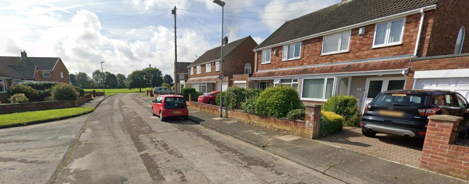 Residential street with parked cars.