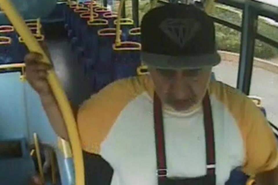 CCTV image of an elderly man with a cap and a yellow and white shirt on a bus.
