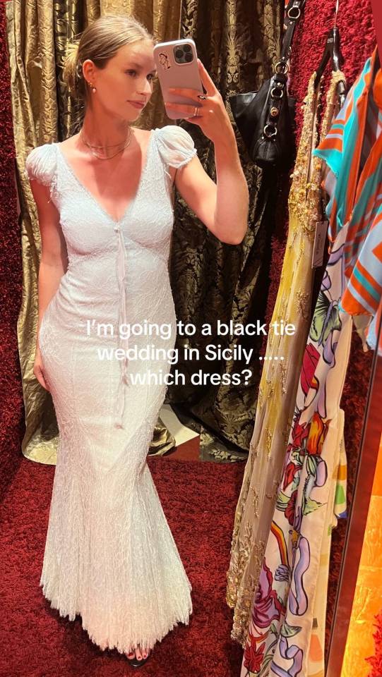 Woman in a white dress taking a selfie, asking which dress to wear to a black-tie wedding in Sicily.