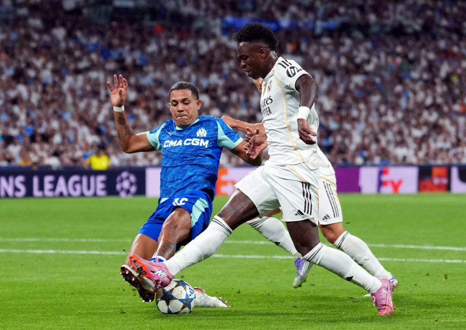 Vinicius Junior of Real Madrid being fouled by Facundo Medina of Olympique de Marseille.
