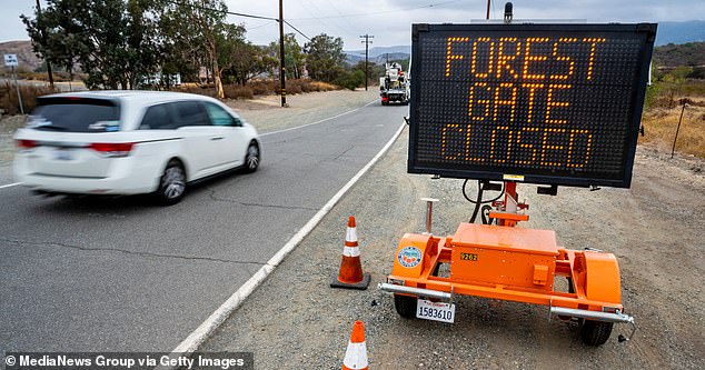 A vehicle passes by a sign on Black Star Canyon Road in Silverado that informs visitors that access to the Cleveland National Forest is closed (file photo)