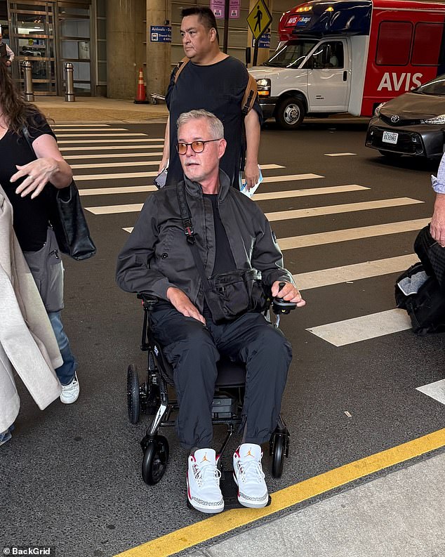 The acclaimed actor, 52, who first revealed his battle with the incurable neurological condition in April, looked frail as he was pushed out of an airport by an aide