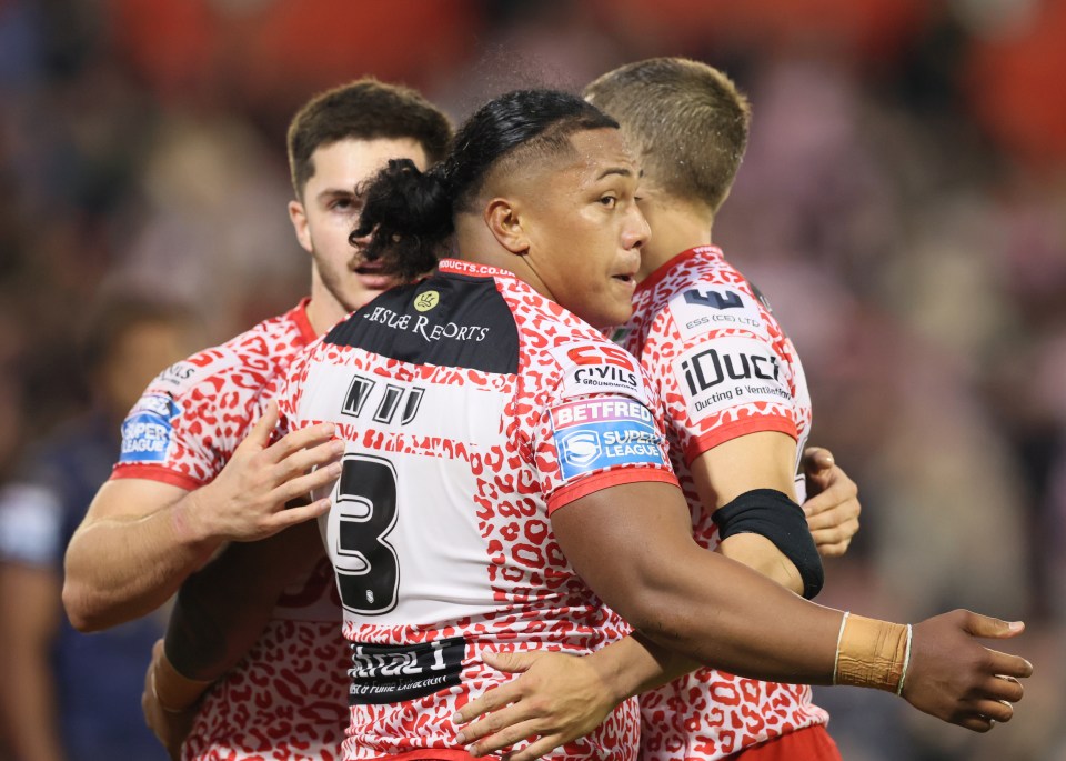 Niu of Leigh Leopards being embraced by teammates.