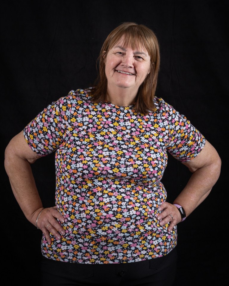 Anne Blacklock, 67, stands smiling with hands on hips.