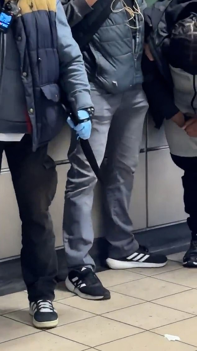 A witness who captured the footage told the Daily Mail they were horrified to see officers reveal the blades as they walked through the station