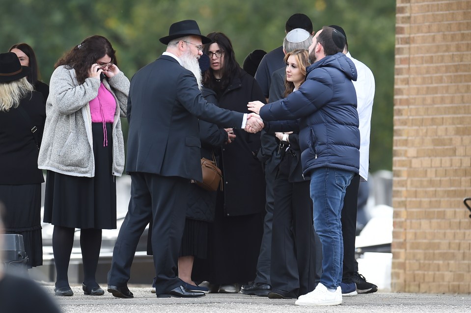 Rabbi Daniel Walker shaking hands with members of the congregation at a funeral.