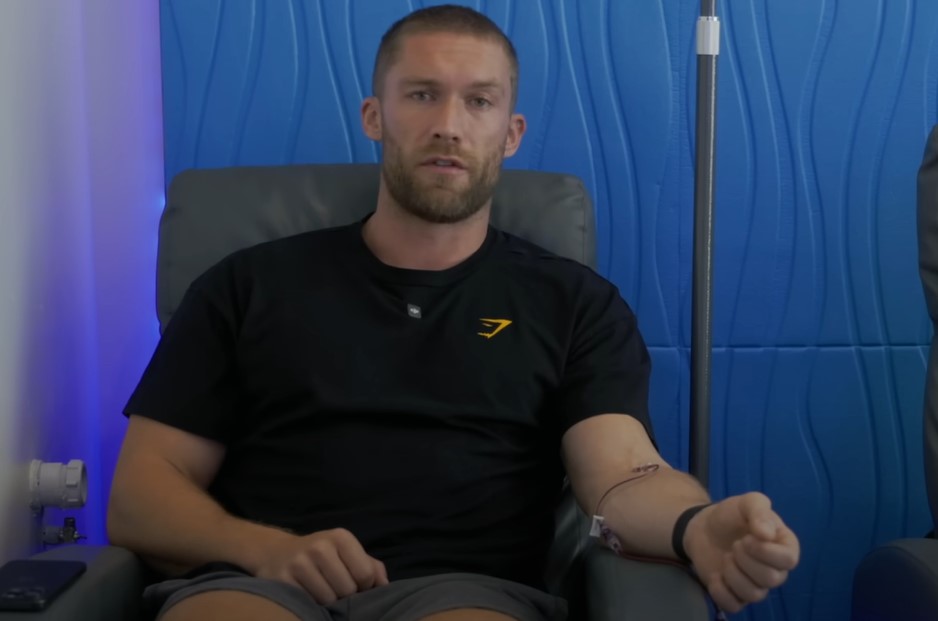 Chris Williamson receiving an IV drip, sitting in a chair.