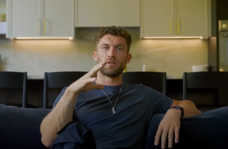 Chris Williamson on a couch, talking.