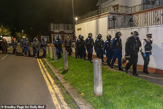 Pictured: A team of Territorial Support Officers about to raid the home of a suspected phone thief in Enfield, north London