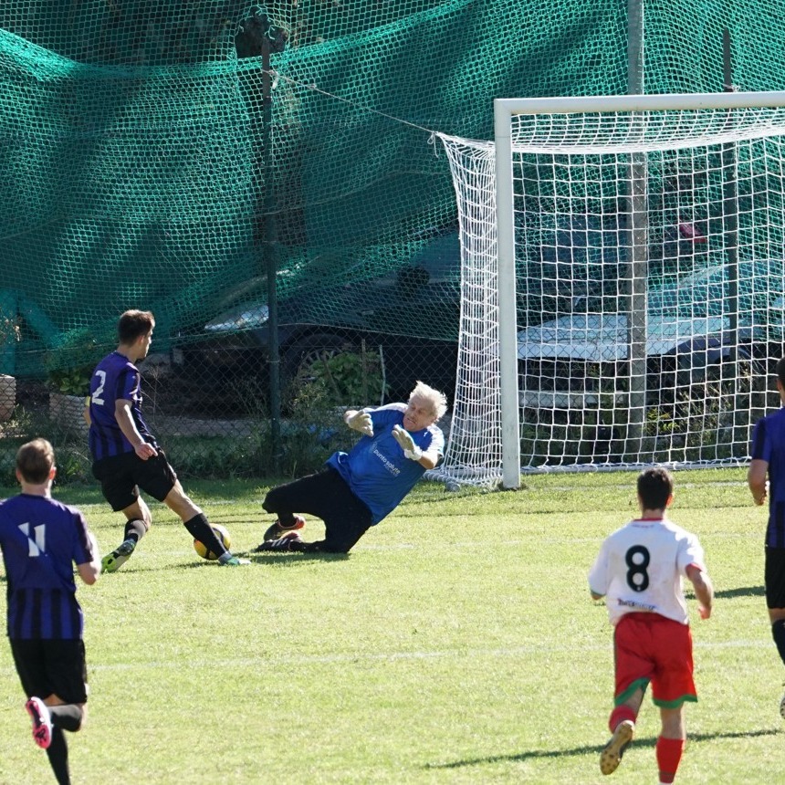Goalkeeper Lamberto Boranga diving to save a soccer ball during a game.