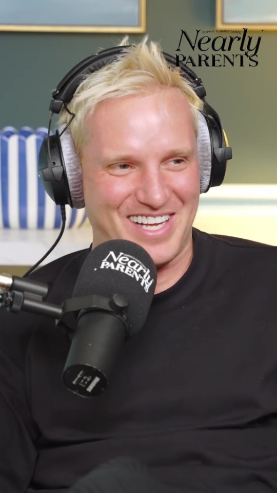 Jamie Laing smiling and wearing headphones, with a "Nearly Parents" podcast microphone in the foreground.
