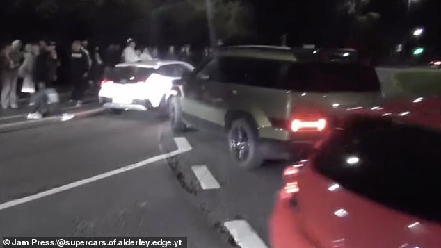 Those watching the speedsters began growing in frustration, with one even lunging to kick the driver's car as he took the exit