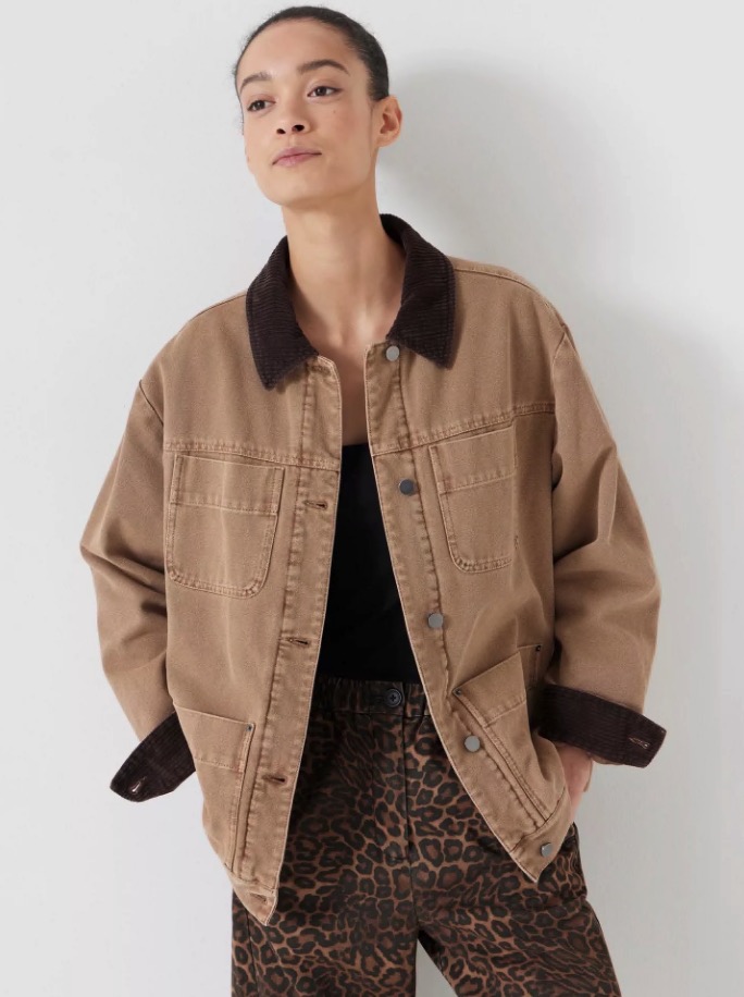 A model wearing a stone-brown corduroy collar jacket over a black top and leopard print pants.